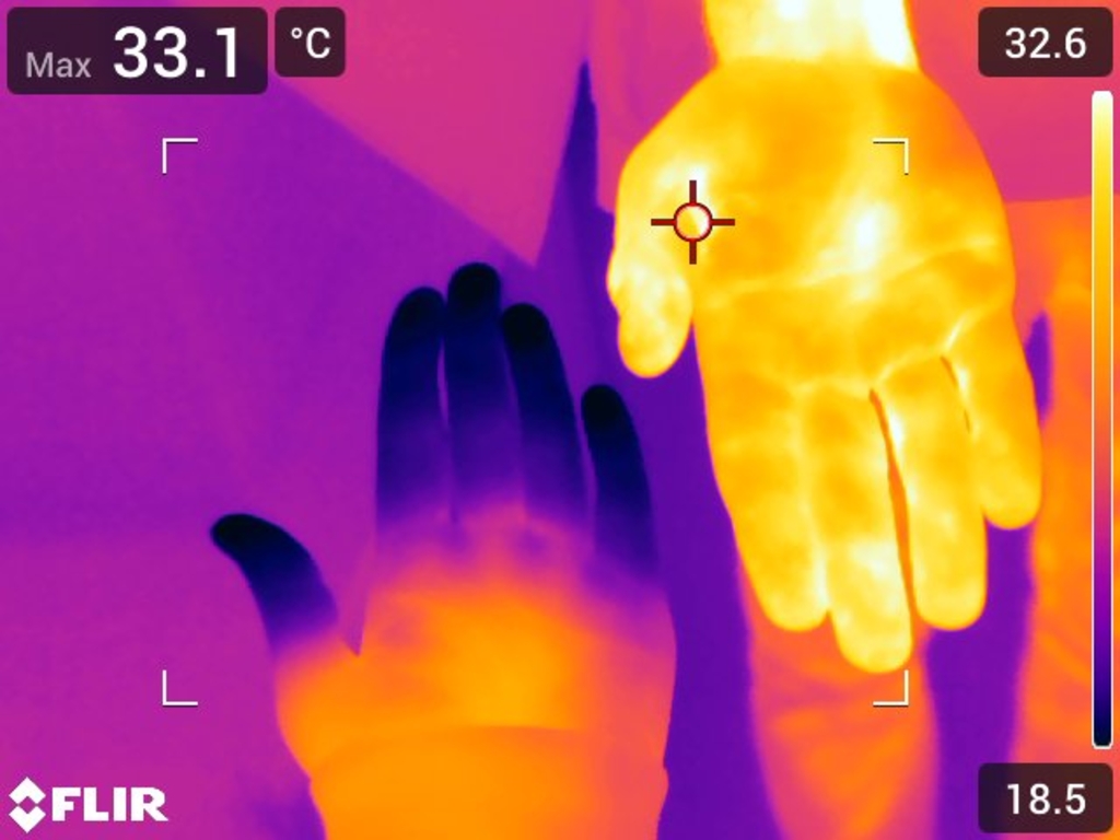Das Bild zeigt zwei Hände in einer Wärmebildaufnahme, wobei die Hand oben eine höhere Temperatur aufweist als die darunter. Die Temperaturanzeigen deutet auf unterschiedliche Wärmeverteilungen hin, die für Experimente im Bildungswesen genutzt werden könne