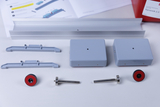 Das Bild zeigt verschiedene Komponenten eines Experimentierkits, darunter graue Kästen, Schrauben, Halterungen und magnetische Elemente. Diese Teile sind zur Durchführung von dynamischen Experimenten im Bildungsbereich konzipiert.