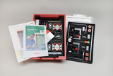 Das Bild zeigt ein Experimentier-Set mit dem Titel "Dynamik 2.0", das in einer roten Box untergebracht ist. Es enthält verschiedene Komponenten, Anleitungen und Materialien zur Durchführung von Experimenten im Bereich der Dynamik für den Schulunterricht.