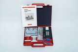 Das Bild zeigt eine rote Box mit Experimentiermaterialien für die Elementarphysik und Elektrik, einschließlich verschiedener elektrischer Komponenten und einem Aufklärungsheft. Die Box ist übersichtlich angeordnet, um Schülern praktische Experimente zu er