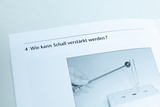 Das Bild zeigt eine Seite eines Lehrbuchs mit der Frage „Wie kann Schall verstärkt werden?“ und einer Illustration, die einen Resonanzkörper und einen Klangstab zeigt. Es ist Teil eines Experiments, um akustische Phänomene zu erkunden.