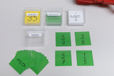 Das Bild zeigt eine Sammlung von Lernmaterialien, darunter gelbe Mengen- und grüne Anteilskarten, die für mathematische Übungen verwendet werden. Außerdem sind einige Karten mit Bruchzahlen abgebildet, die möglicherweise für das Training von Rechenfähigke