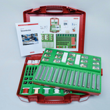 Das Bild zeigt ein rotes Koffer-Set für Experimente im Bereich Elektrotechnik, das verschiedene Bauteile und Materialien für die Durchführung von Stromkreisprojekten enthält. Zudem liegt eine Anleitung bei, die Gestaltungsmöglichkeiten und Versuche erklär