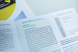 Das Bild zeigt eine Seite aus einer Versuchsanleitung, die sich mit der Kalibrierung eines Flüssigkeitsthermometers beschäftigt. Der Text erläutert den Aufbau des Experiments und die Vorgehensweise zur Bestimmung von Temperaturfixpunkten mithilfe von Wass