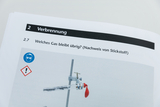 Das Bild zeigt eine Seite aus einem Lehrbuch mit der Überschrift "Verbrennung" und der Frage zur identifizierten Gase, insbesondere Stickstoff. Zusätzlich sind Warnsymbole und ein Hinweis auf Schutzbrillen abgebildet, die auf Sicherheitsvorkehrungen während des Experiments hinweisen.
