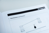 Das Bild zeigt eine Abbildung, die sich mit der Belastbarkeit von Knochen beschäftigt. Es enthält ein Diagramm mit einem Balken, an dem zwei durchsichtige Röhren und ein Gewicht aufgehängt sind.