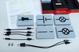 Das Bild zeigt ein Set für physikalische Experimente, bestehend aus mehreren Experimentierplatten mit verschiedenen Symbolen, die elektrische Schaltungen darstellen. Daneben liegen Anschlusskabel und zwei Glühbirnen, sowie ein Arbeitsblatt für die Durchführung der Experimente.