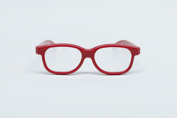 Das Bild zeigt eine rote Brille mit klaren Gläsern, die zentral auf einem weißen Hintergrund platziert ist. Sie ist für experimentelle Bildungszwecke konzipiert und könnte in Schulen oder für wissenschaftliche Anwendungen verwendet werden.