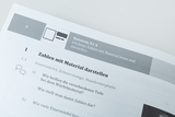 Das Bild zeigt ein Arbeitsblatt mit der Überschrift „Zahlen mit Material darstellen“. Es enthält Fragen zu verschiedenen Materialien wie Einwürfeln und einer Zehnerstange, die im Unterricht zur Veranschaulichung von Zahlen genutzt werden.