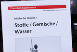 Das Bild zeigt eine Informationskarte für ein Schüler-Set in Chemie, das sich mit Stoffen, Gemischen und Wasser beschäftigt. Der Titel deutet auf eine Versuchsbeschreibung oder Gebrauchsanleitung hin, die im Rahmen des Unterrichts verwendet wird.