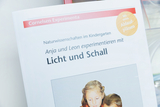 Das Bild zeigt ein Buch über naturwissenschaftliche Experimente im Kindergarten, in dem Kinder mit Licht und Schall arbeiten. Es enthält Anleitungen und Ablaufschemen für die Durchführung der Experimente.