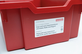 Das Bild zeigt einen roten Experimentierkasten mit dem Titel "Anja und Leon experimentieren mit Hebel, Rolle und Magnet". Auf dem Etikett sind die Informationen für eine Kindergarten-Experimentierreihe auf Deutsch und Englisch angegeben.