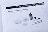 Das Bild zeigt Materialien zur Durchführung eines Experiments zum Nachweis von Stärke in Keimblättern. Es umfasst Jodlösung, verschiedene Pipetten und Schalen, die für die Experimentieranordnung benötigt werden.