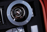 Das Bild zeigt ein Experimentiergerät, das in einem Schutzkasten aus Schaumstoff untergebracht ist. Im Zentrum befindet sich ein metallischer Halter mit einer Probe, umgeben von verschiedenen weiteren Komponenten wie Behältern und Zubehörteilen.