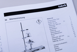 Das Bild zeigt eine Seite aus einem Katalog für Experimentierbedarf, auf der das Thema „Wärmeströmung“ behandelt wird. Es sind Materialien aufgelistet, die für ein Experiment benötigt werden, einschließlich einer Abbildung der benötigten Ausrüstung.