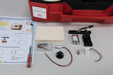 Das Bild zeigt ein Experimentier-Set namens "eXperTeenies - Luft", das verschiedene Komponenten wie Batterien, Schaltungen und eine Anleitung enthält. Diese Materialien dienen zur Durchführung von Experimenten im Bildungsbereich, insbesondere zur Erforschung von Luft und elektrischen Schaltungen.