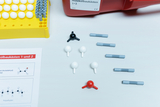 Das Bild zeigt einen Molekülbaukasten mit verschiedenen bunten Teilen, die Atome und Bindungen repräsentieren. Zudem ist ein Arbeitsblatt zu sehen, das Informationen über chemische Strukturen, wie Acetaldehyd und Polyethylen, enthält.