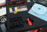 Das Bild zeigt ein Experimentier-Kit, das verschiedene Materialien für den Unterricht enthält, darunter farbige Würfel, eine rot-weiße Schicht, CD-Scheiben und eine Metall-Schale. Diese Utensilien sind ordentlich in einem Schaumeinsatz angeordnet, um sie zu schützen und zu organisieren.
