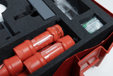 Das Bild zeigt ein stabil verpacktes Set mit zwei roten Taschenlampen und weiteren Experimentiermaterialien in einem Schaumstoffeinsatz. Die Anordnung im roten Koffer deutet darauf hin, dass es sich um ein Set für Bildungszwecke handelt.