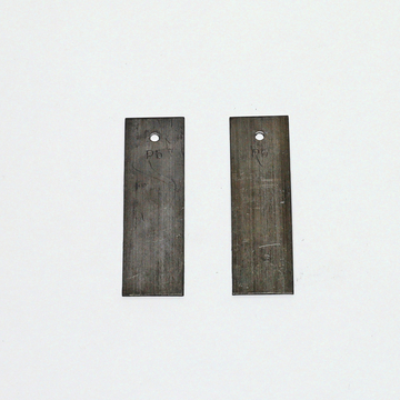 Das Bild zeigt zwei metallene Platten mit Löchern am oberen Ende, die zur Verwendung in Experimenten im Bildungsbereich gedacht sind. Beide Platten sind beschriftet und scheinen aus dem gleichen Material zu bestehen, möglicherweise aus Blei.