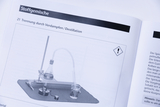 Das Bild zeigt eine Anleitung zur Durchführung einer Destillation, einschließlich einer Abbildung des benötigten Equipments wie einer Heizplatte, einem Erlenmeyer und einem Kühler. Die Informationen sind Teil eines Lehrbuchs über Stoffgemische im Bildungswesen.