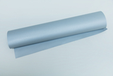 Das Bild zeigt eine Rolle in hellblauem Material, die auf einer flachen Oberfläche liegt. Der Stoff scheint eine strukturierte Oberfläche zu haben und könnte für experimentelle Zwecke im Bildungsbereich verwendet werden.