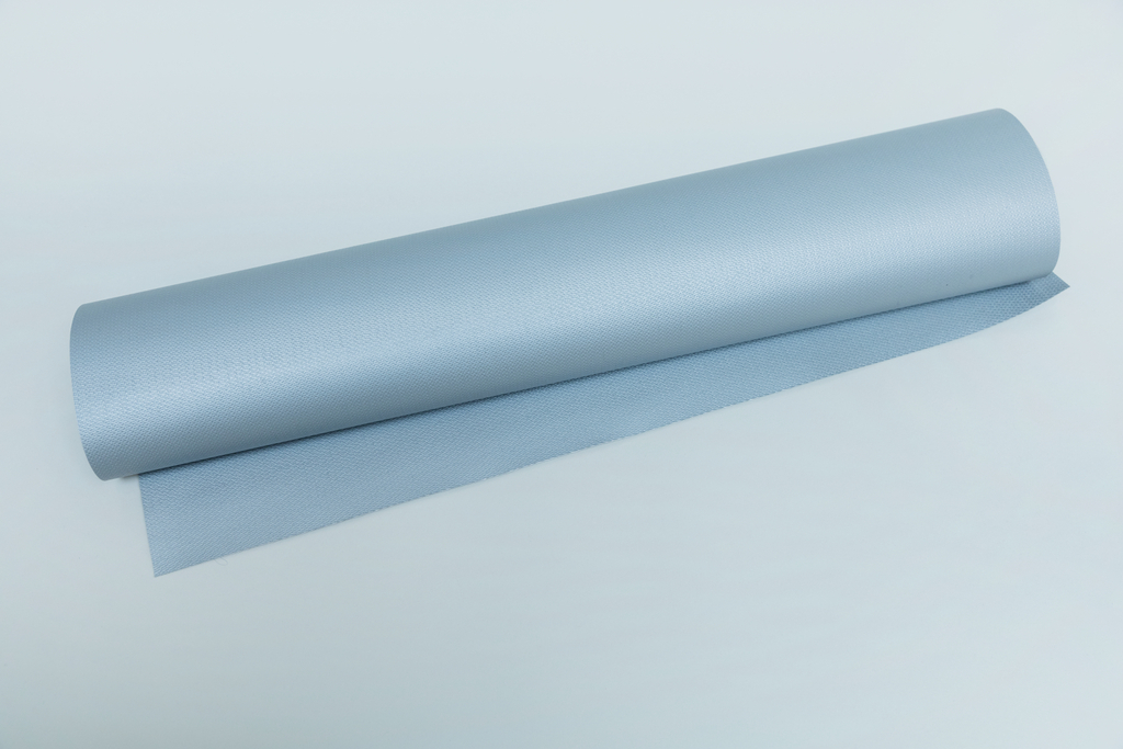 Das Bild zeigt eine Rolle in hellblauem Material, die auf einer flachen Oberfläche liegt. Der Stoff scheint eine strukturierte Oberfläche zu haben und könnte für experimentelle Zwecke im Bildungsbereich verwendet werden.