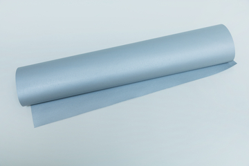 Das Bild zeigt eine Rolle in hellblauem Material, die auf einer flachen Oberfläche liegt. Der Stoff scheint eine strukturierte Oberfläche zu haben und könnte für experimentelle Zwecke im Bildungsbereich verwendet werden.