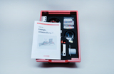 Das Bild zeigt ein Schüler-Set zur Energieumwandlung, das in einem roten Ablagesystem untergebracht ist. Neben verschiedenen Experimentiermaterialien liegt ein Anleitungsheft, das die Durchführung der Experimente erklären soll.