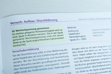Das Bild zeigt eine Anleitung für ein Experiment zur Erzeugung von Wechselspannung mit einem rotierenden Permanentmagneten vor einer Spule. Es enthält Informationen zu den Materialien und der Durchführung des Versuchs, um grundlegende physikalische Konzepte zu erforschen.