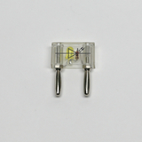 Das Bild zeigt einen durchsichtigen Schaltkreis mit zwei metallischen Verbindungselementen und einem gelben Bauteil, wahrscheinlich einer LED. Der Aufbau ist für Experimente in der Elektronik und im Bildungsbereich geeignet, um grundlegende elektrische Konzepte zu vermitteln.