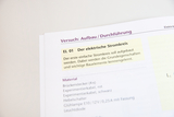 Das Bild zeigt eine Anleitung für den Aufbau eines einfachen elektrischen Stromkreises. Der Text beschreibt den Versuch und listet benötigtes Material wie Brückenstecker, Experimentierkabel und eine Glühlampe auf.
