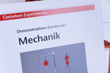 Das Bild zeigt eine Produktbeschreibung für einen Demonstrations-Gerätesatz zur Mechanik von Cornelsen Experimenta. Der Satz enthält Vorrichtungen, die zur Veranschaulichung mechanischer Prinzipien eingesetzt werden können.