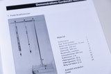 Das Bild zeigt eine Illustration eines Federkraftmessers samt der zugehörigen Materialien auf einer Seite eines Katalogs für Experimentierbedarf. Die Liste beschreibt die einzelnen Komponenten und deren Anzahl, die für den Aufbau benötigt werden.