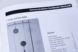 Das Bild zeigt eine Seite aus einem Handbuch für Demonstrationsgeräte zur Mechanik im Bildungswesen. Es sind Angaben zu einem Experiment mit festen und losen Rollen sowie eine Materialliste aufgeführt.