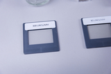 Das Bild zeigt zwei Mikroskopie-Objekte mit Etiketten, die die Linienanzahl pro Millimeter angeben: eines mit 300 Linien/mm und das andere mit 80 Linien/mm. Diese Objekte sind Teil des Experimentierbedarfs für das Bildungswesen.