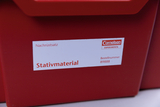Das Bild zeigt eine rote Box mit einem Etikett, das das Produkt "Stativmaterial" aus dem Sortiment von Cornelsen Experimenta anzeigt. Es ist ein Nachrüstsatz zu sehen, begleitet von einer Bestellnummer.