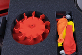 Das Bild zeigt einen Behälter mit einer roten, sternförmigen Kunststoffauflage und mehreren bunten Luftballons in orange, gelb und rot. Der Inhalt ist ordentlich in einem Schaumstoffeinsatz platziert, der für Experimente im Bildungsbereich genutzt werden kann.