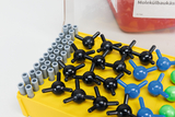Das Bild zeigt einen Molekülbaukasten mit verschiedenen Größen und Farbvariationen von Kunststoffatomdarstellungen in Schwarz, Blau und Grün, die auf einer gelben Basis angeordnet sind. Diese Modelle dienen zur Veranschaulichung von chemischen Strukturen und Molekülorientierungen im Bildungsbereich.