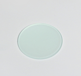 Das Bild zeigt eine gläserne Deckglasplatte in kreisförmiger Form. Sie wird häufig in Experimenten und Mikroskopie verwendet, um Proben zu schützen und zu präsentieren.
