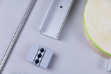 Das Bild zeigt verschiedene Bauteile aus Metall und Holz, die für Experimente und Bildungsprojekte im Schulwesen verwendet werden könnten. Zu sehen sind unter anderem ein Aluminiumprofil, eine runde Holzplatte sowie mehrere graue Kunststoffelemente.