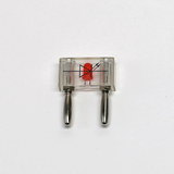 Das Bild zeigt ein transparentes Versuchsgerät mit einer roten Diode und zwei Metallstiften. Es dient wahrscheinlich zur Veranschaulichung von elektrischen Komponenten im Bildungsbereich.