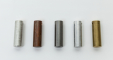 Das Bild zeigt fünf unterschiedlich gefärbte Zylinder aus Metall, die in einer Reihe angeordnet sind. Sie variieren in Farbe und Material und könnten für experimentelle Zwecke im Bildungswesen verwendet werden.