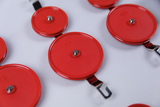 Das Bild zeigt mehrere rote Experimentiervorrichtungen, die durch Metallklammern miteinander verbunden sind. Sie sind wahrscheinlich Teil eines wissenschaftlichen Sets für den Einsatz im Bildungsbereich, zum Beispiel für physikalische Experimente.