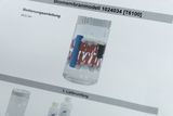 Das Bild zeigt ein Biombrennstabmodell in einem transparenten Behälter mit verschiedenen farbigen Komponenten, die wahrscheinlich für Experimente im Bildungsbereich verwendet werden. Es ist Teil einer Bedienungsanleitung, die die Nutzung des Modells beschreibt.