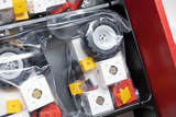 Das Bild zeigt eine Sammlung von Bauteilen in durchsichtigen Verpackungen, die für den Experimentierbedarf im Bildungskontext bestimmt sind. Die Teile umfassen Räder und verschiedene farbige Blöcke, die für den Bau und die Durchführung von Experimenten verwendet werden können.