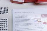 Auf der Oberfläche sind verschiedene Materialien für den Experimentierbedarf zu sehen, darunter eine Anleitung zur Handhabung und Blätter mit kreisförmigen Stempeln. Die Materialien scheinen für den Unterricht in Mathematik konzipiert zu sein, um Schüler beim Lernen zu unterstützen.