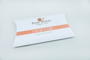 Ein ansprechend gestalteter Karton enthält ein T-Shirt mit dem Titel "Magic T-shirt" von Body Planet. Die Verpackung vermittelt den Eindruck, dass das Produkt eine unterhaltsame und lehrreiche Erfahrung bietet.