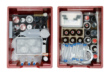 Das Schüler-Set Chemie III mit dem Thema Säuren, Laugen und Salze mit den beiden Experimentierwannen ist von oben gezeigt, man kann gut hineinsehen und die Materialien erkennen.