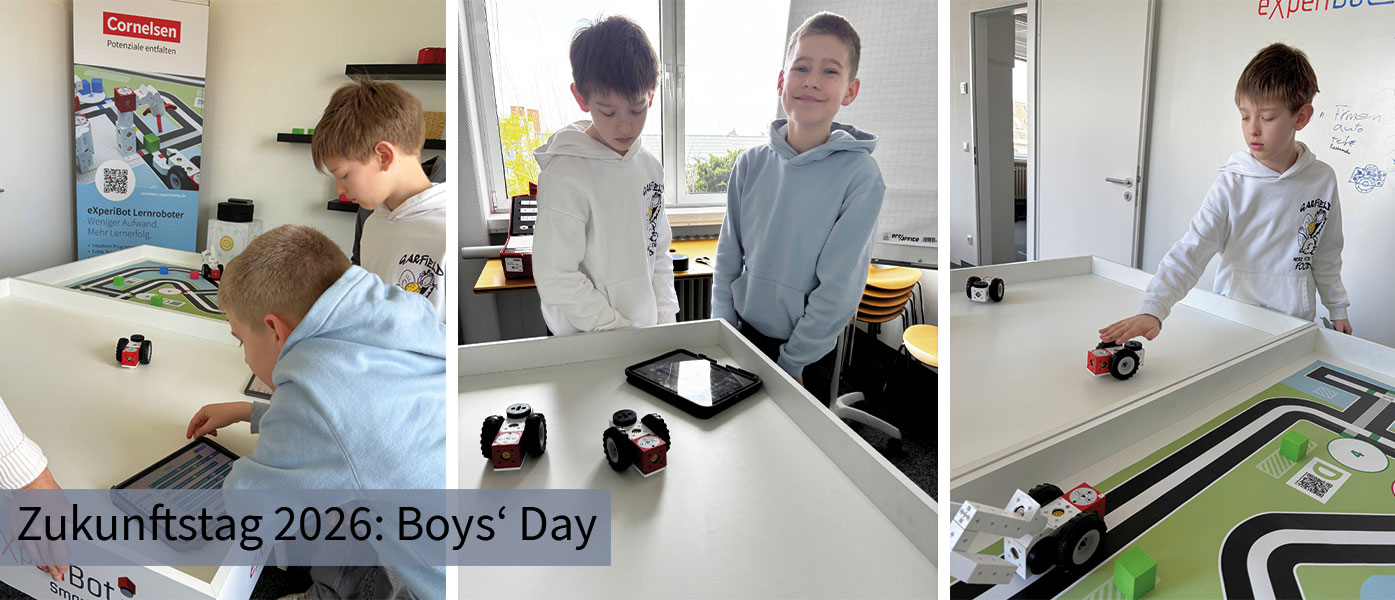 Im Bild sind zwei Jungen zu sehen, die an einem Tisch mit einem Spielbrett arbeiten, auf dem sich kleine Roboterfahrzeuge befinden. Auf einem Tablet scheinen sie Programmierungs- oder Steuerungsanweisungen f&uuml;r die Fahrzeuge einzugeben.